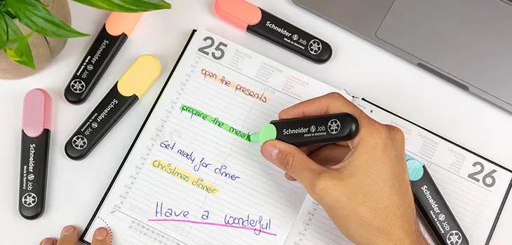 In einem Buchkalender wird mit dem Schneider Job Textmarker markiert.