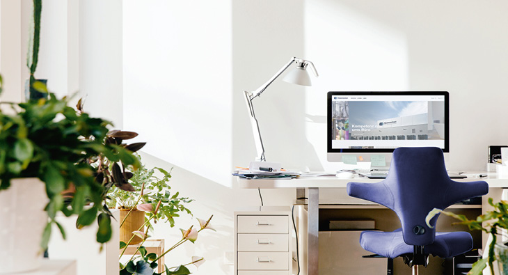 Blick auf einen Arbeitsplatz im Homeoffice in einem hellen Raum.