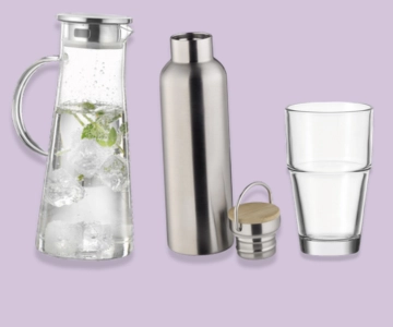 Glas, Flasche und Karaffe vor lila Hintergrund