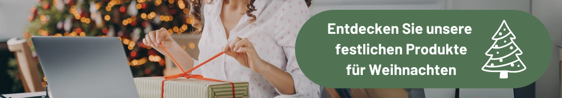 Eine Frau sitzt vor einem Computer und packt ein Geschenk aus.