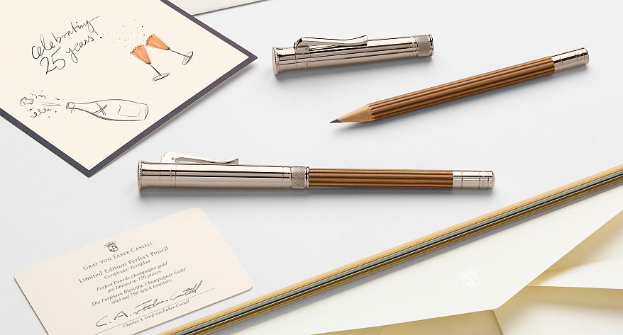 Auf einem Tisch liegen 2 Perfekte Bleistifte von Faber-Castell sowie eine Geburtstagseinladung.