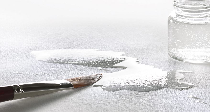 Wasser wird mit einem Pinsel auf Büttenpapier aufgetragen.