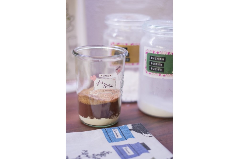 Ein Glas mit geschichteten Zutaten für Brownies.