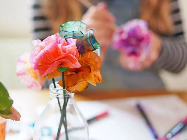 Ein Kind malt am Küchentisch. Vor ihm steht eine Vase mit Papierblumen, die aus Bastelmaterialien von HEYDA und KNORR prandell selbst hergestellt wurden. Foto: Johanna Rundel