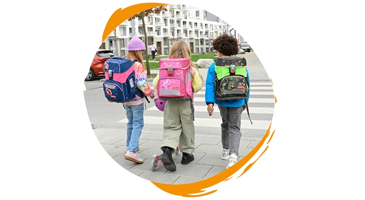 Drei Kinder mit einem Step by Step Schulranzen überqueren einen Zebrastreifen.