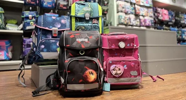 Viele bunte Schulranzen der Marken ergobag, Step by Step und Scout stehen im Regal und davor.
