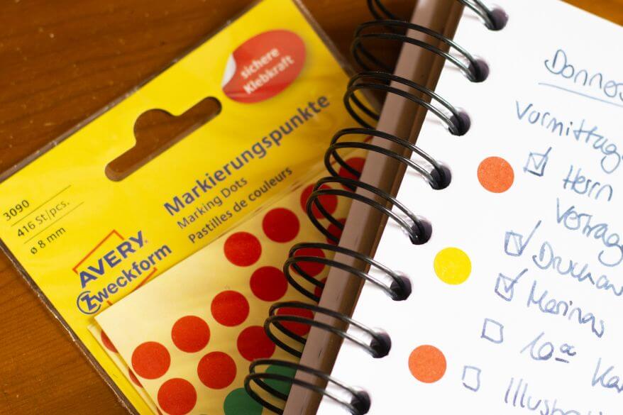 Nahaufnahme eines Stickerbogens von Avery Zweckform mit Markierungspunkten in verschiedenen Farben.
