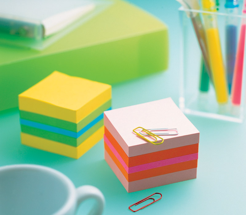 2 bunte Post-it Blöcke in Nahaufnahme auf einem Tisch.
