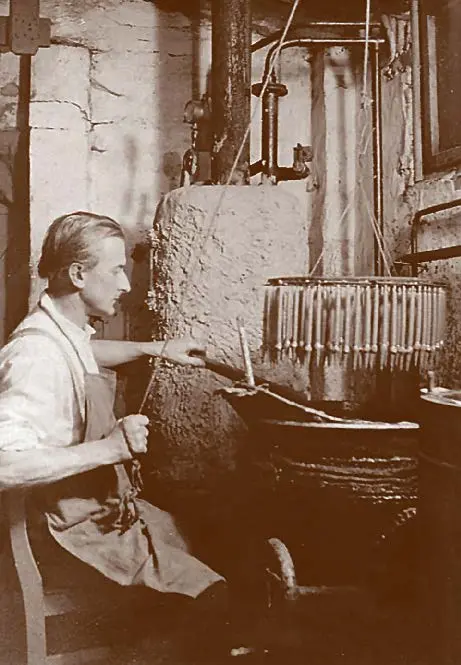 Schwarz-weiß-Fotografie von Hans Stockmar beim Kerzenziehen, Firmengründer von STOCKMAR