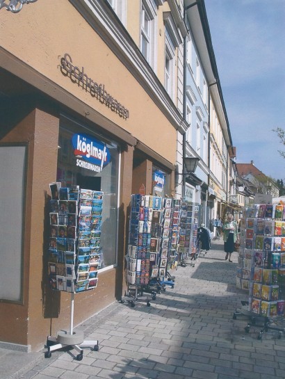 Aussenansicht von Köglmayr in Murnau im Jahr 2000 mit zahlreichen Aufstellern mit Post- und Grußkarten.