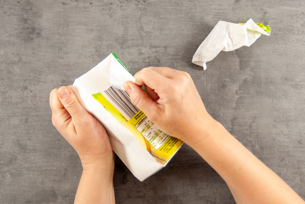 Die Papierschicht eines Getränkekartons wird abgezogen