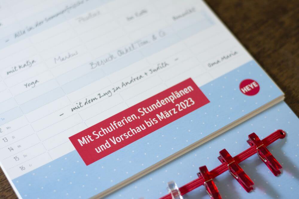 Nahaufnahme eines Familienplaners von Heye, auf dem in einem roten Kasten der Text steht "MIt Schulferien, Stundenplänen und Vorschau bis März 2023".
