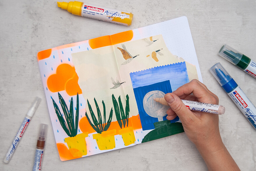 Jemand malt mit einem Acrylstift von Edding ein Gesicht in ein Art Journal im Mixed-Media-Stil. Drumherum liegen weitere Acrylmarker in verschiedenen Farben. Foto: Johanna Rundel