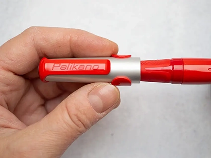 Jemand steckt die Schutzkappe auf einen roten Pelikano-Füller von Pelikan. Foto: Johanna Rundel