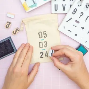 Jemand bestempelt kleine Jutesäckchen von KNORR prandell mit Geburtstag, Größe, Gewicht eines Babys. Foto: Johanna Rundel