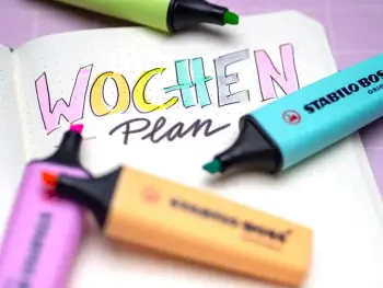 Ein aufgeschlagenes Journal, auf der Seite steht in bunten Buchstaben „Wochen“, darunter in schwarz „plan“. Rundherum liegen Textmarker von STABILO. Foto: Johanna Rundel