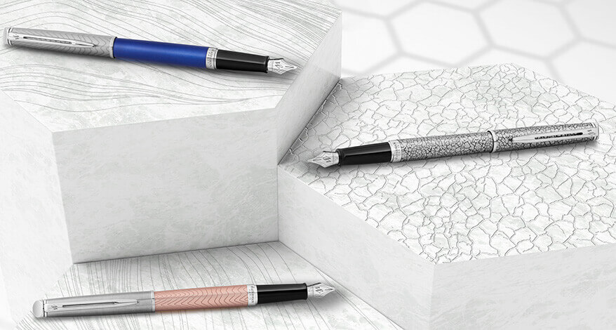 Drei Füllfederhalter von Waterman auf stilisierten, weißen Podesten arrangiert.