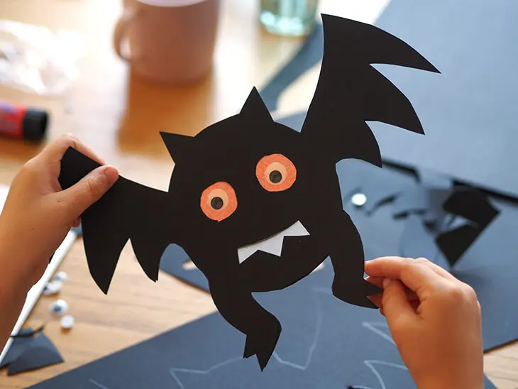 Kind hält selbstgebastelte HEYDA Fotokarton Fledermaus in Kamera. Foto: Johanna Rundel