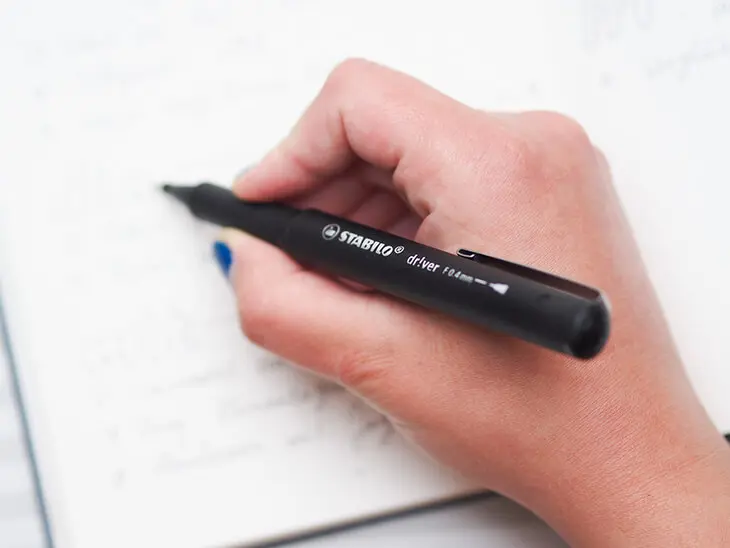 Jemand schreibt mit einem Tintenfeinschreiber von STABILO in ein BuJo. Foto: Johanna Rundel