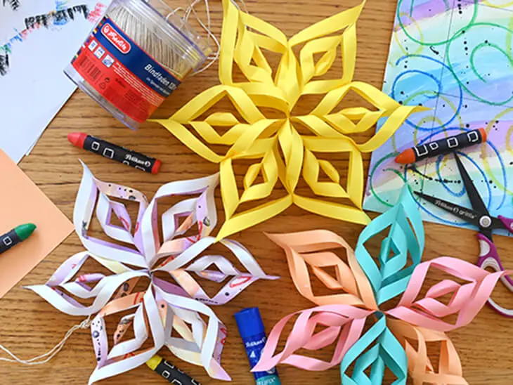 Mit Material von herlitz und Pelikan gebastelte Papiersterne liegen auf einem Basteltisch. Foto: Johanna Rundel