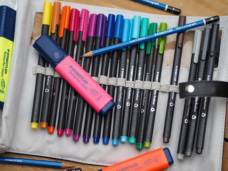 Verschiedene Stifte und Marker von STAEDTLER liegen verstreut auf einem Tisch. Foto: Johanna Rundel)