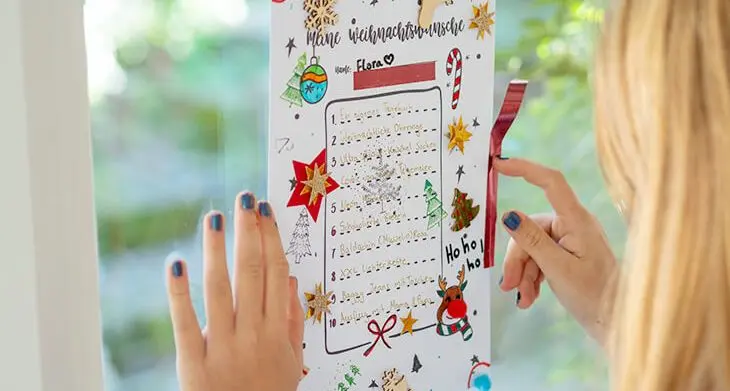 Ein Kind klebt seinen Wunschzettel mit Tape von HEYDA ins Fenster. Foto: Johanna Rundel)