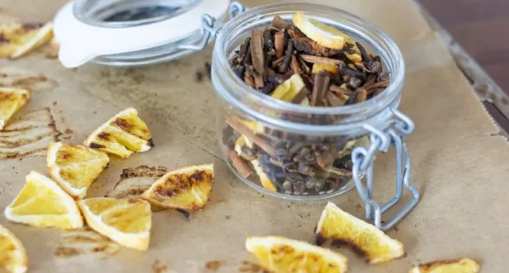 Auf Backpapier liegen Zitronenscheiben, in einem Weckglas ist eine selbstgemachte Punschmischung