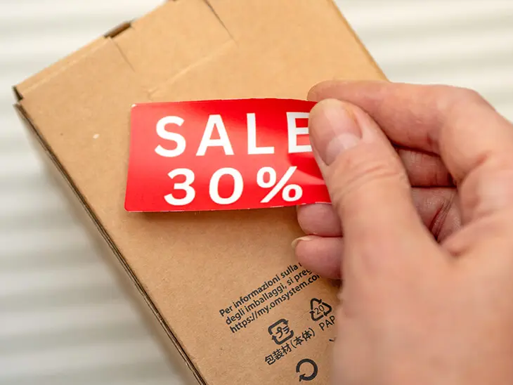 Jemand klebt ein Sale-Etikett von Avery Zweckform auf einen Karton. Foto: Johanna Rundel