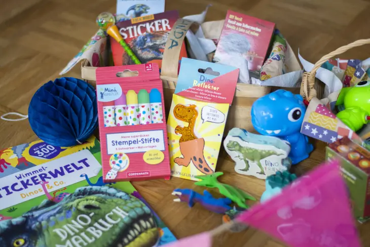 Viele Geschenkartikel zum Thema Dino von Coppenrath liegen in einem Körbchen