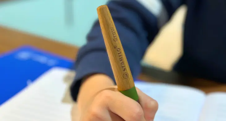 Ein Kind schreibt mit dem Schulfüller GROW von STABILO in ein Schulheft