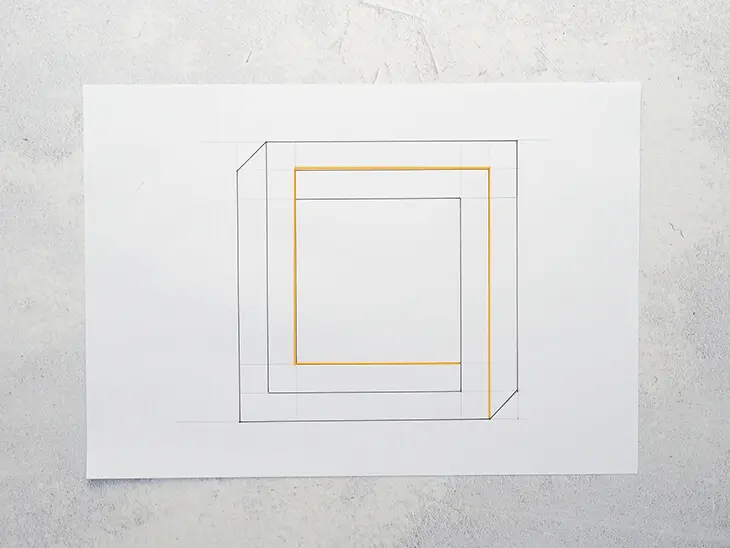 Ein gezeichnetes Quadrat mit orangener Innenlinie auf einem weißen Blatt. Foto: Johanna Rundel