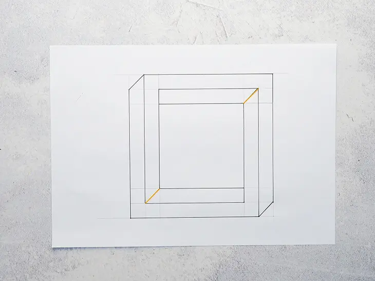 Ein gezeichnetes unmögliches Quadrat mit orangener Diagonallinien auf einem weißen Blatt. Foto: Johanna Rundel