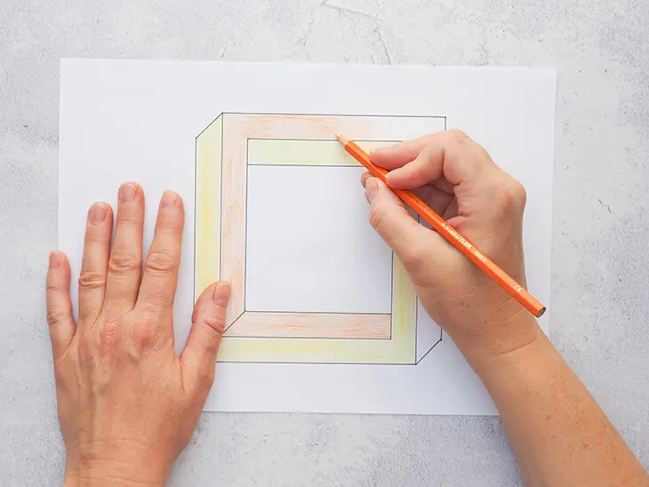 Jemand malt mit einem STAEDTLER Buntstift ein unmögliches Quadrat orange aus. Foto: Johanna Rundel