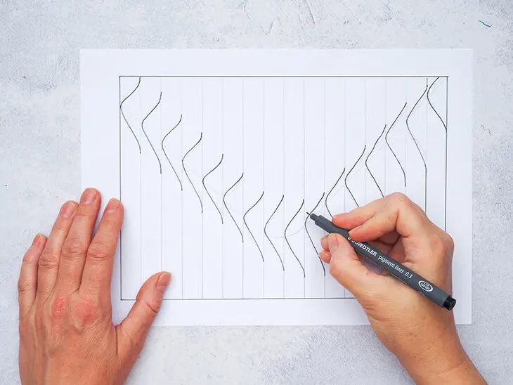 Jemand zeichnet mit einem STAEDTLER Bleistift Wellen auf ein Streifenmuster. Foto Johanna Rundel