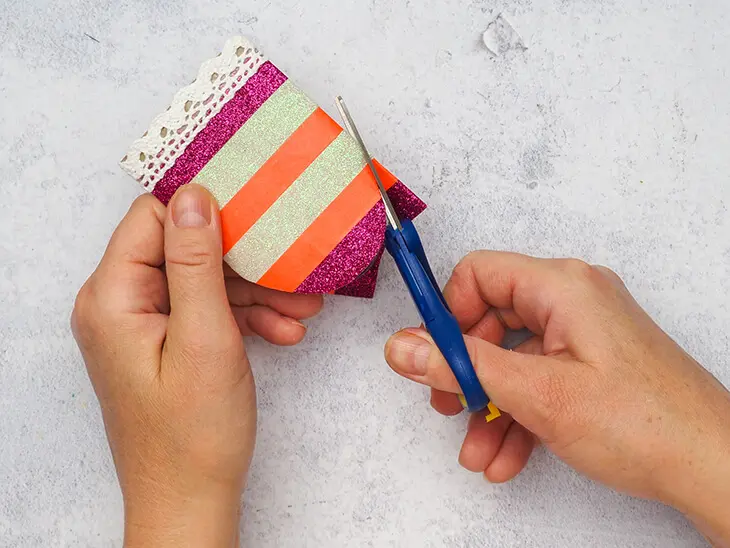 Jemand beschneidet eine bunt beklebte Klopapierrolle mit einer HEYDA Schere. Foto: Johanna Rundel
