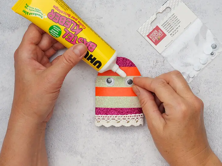 Jemand klebt Wackelaugen von KNORR prandell auf eine bunte Klopapierrolle. Foto: Johanna Rundel