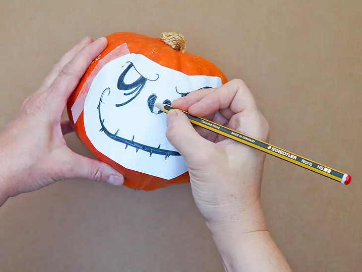 Jemand überträgt mit einem Bleistift von STAEDTLER eine Halloween-Fratze auf einen Kürbis. Foto: Johanna Rundel