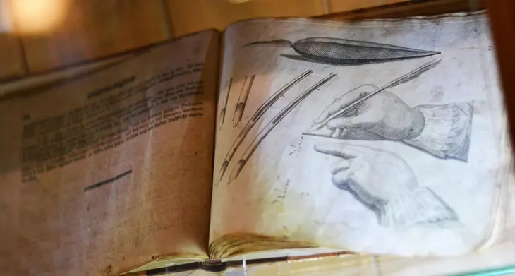 Blick in ein altes Buch mit Abbildungen von historischen Schreibfedern.