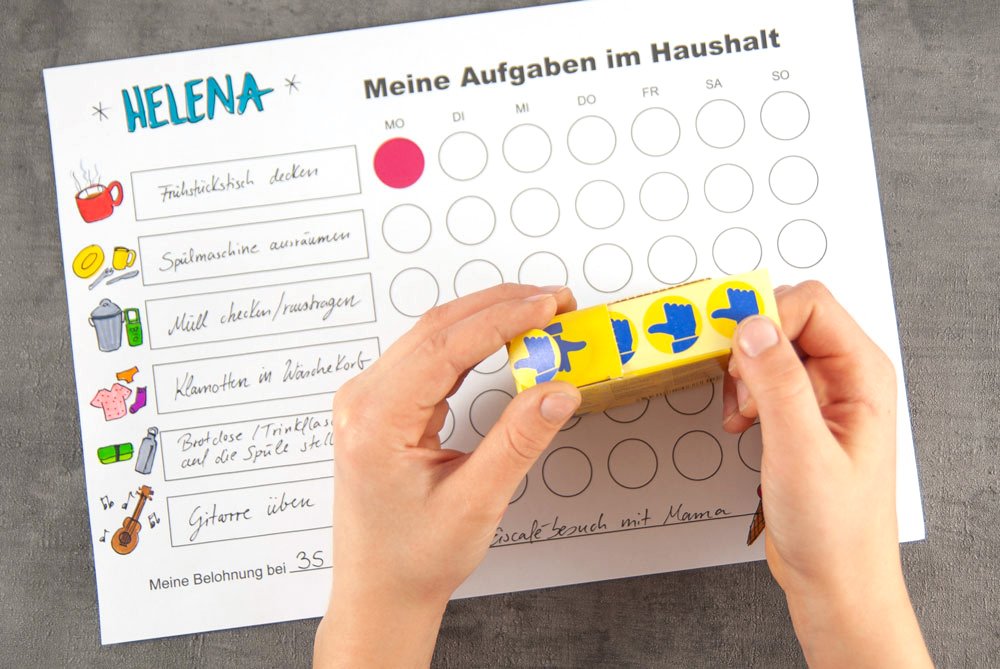 Ein Mädchen hat die Bewertungspunkte im Roller von Avery Zweckform in der Hand. Im Hintergrund ist ihre Aufgabentafel zu sehen.