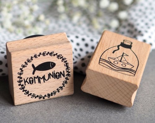 Zwei Holzstempel von Artoz mit Motiven zur Kommunion: Fisch mit Schriftzug "Kommunion" und Flaschenschiff.