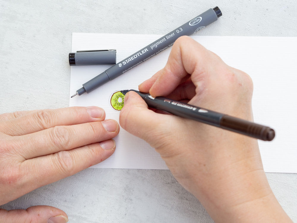 Feinliner umrundet gemalte Kiwi-Zeichnung