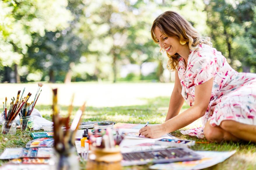 Clarissa Hagenmeyer malt auf einer Wiese Bilder.