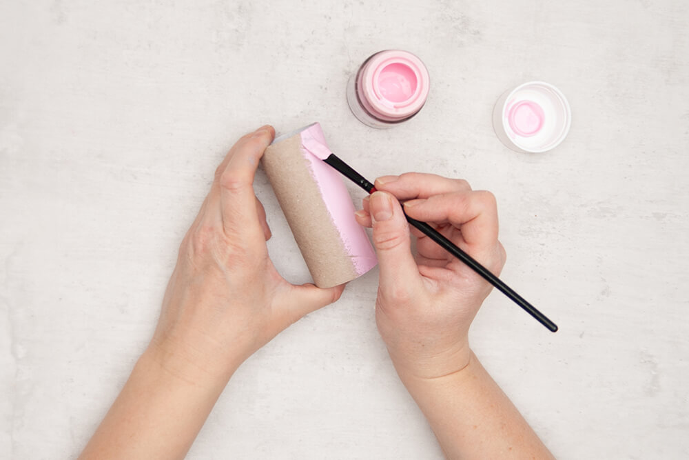 Eine Klopapierrolle wird von außen mit Rosa Acrylfarbe bemalt. Fotos: Johanna Rundel