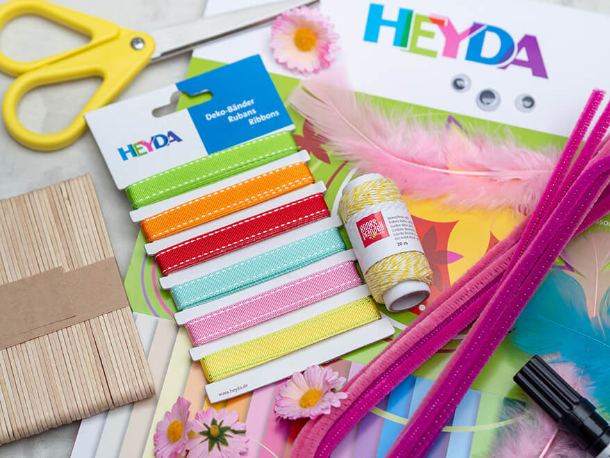 Verschiedene Bastelmaterialien der Marken Heyda und Knorr-Prandell liegen auf einem weißen Untergrund verteilt. Fotos: Johanna Rundel