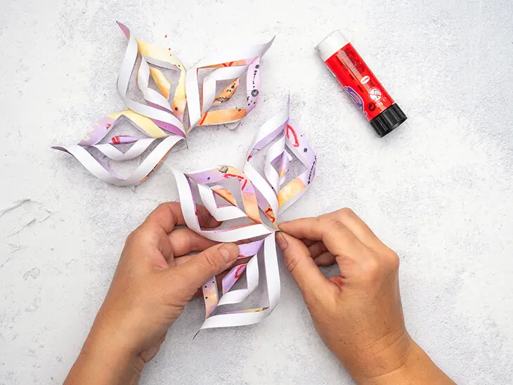 Jemand klebt einen bunten Papierstern zusammen. Foto: Johanna Rundel