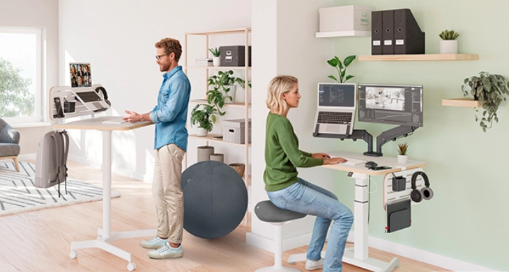 Zwei Personen sitzen an Ihren ergonomischen Schreibtischen.