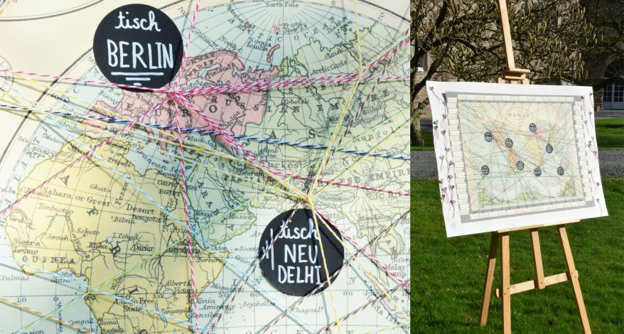 Weltkarte mit Fäden und Tischaufklebern versehen, daneben Staffelei mit der Weltkarte.
