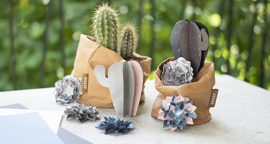 Zwei gebastelte Papiersukkulenten und Papierblumen in braunen Papiertöpfen