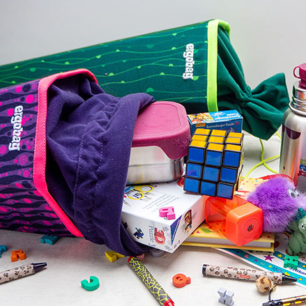 Ergobag Schultüte gefüllt mit verschiedenen Utensilien: Anspitzer, Stifte, Thermoskanne, Plüschtier...