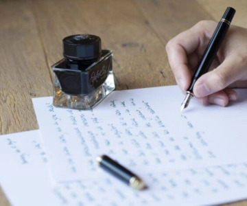 Eine Person schreibt mit Füller auf ein Papier.